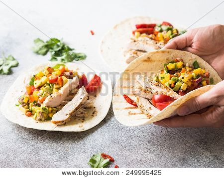 Tortillas With Grilled Chicken Fillet, Salsa Mango Sauce And Tomatoes. Female Hands Hold One Tortill