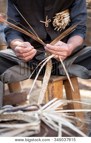 Wicker Craftsman Working With His Hands In The Manufacture Of A Basket