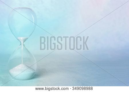 Time Concept. An Hourglass With The Period Coming To An End, With Copy Space, In Teal Blue, Toned Im