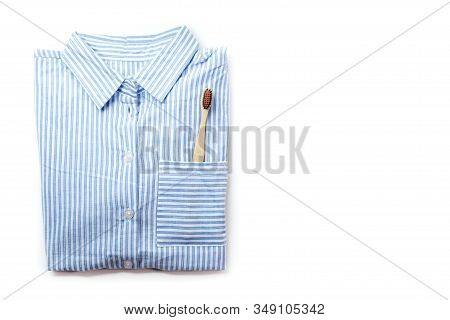 Pajamas Shirt And Wooden Toothbrush On A White Background