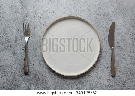 Modern Modus, Fork And Knife On Grey Stone Table. Minimal Table Place Setting. Space For Text Or Men