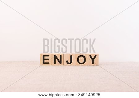 Wooden Cubes With Words Enjoy On A Light Background