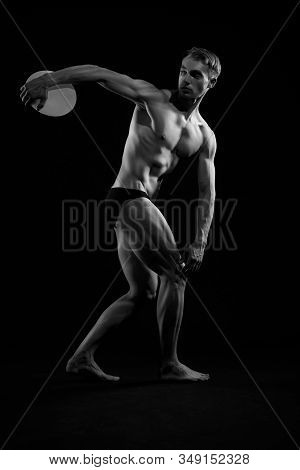 Side View Of Young Athletic Man With Perfect Body And Tensed Muscles Throwing Discus. Monochrome Por