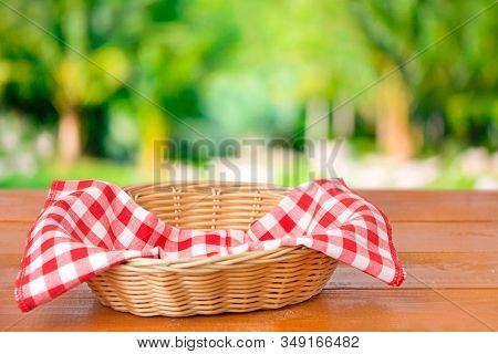 Basket With Red Checkered Cloth Inside On A Wooden Table