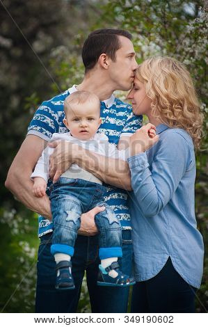 Happy Family Mother, Father, Little Son For A Walk In The Summer Park.happy Young Family Spending Ti
