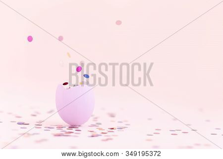 Purple Easter Eggshell On Pastel Pink Background With Flying Out Colorful Confetti. Egg Is A Symbol