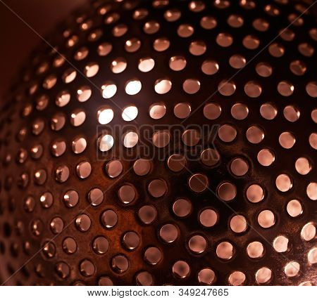 Metal Sphere With Holes And Light Iside. Perforated Surface Background