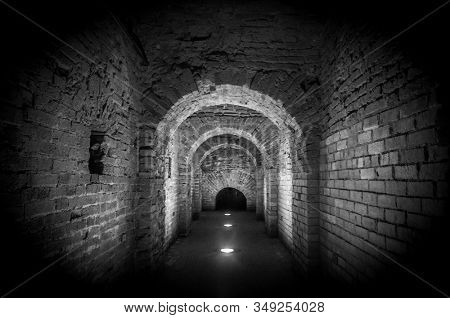 Brick tunnel archway made of red bricks as a passage between the two wings of a medieval castle. Granite stone an brick built Interior corridor way to bastions