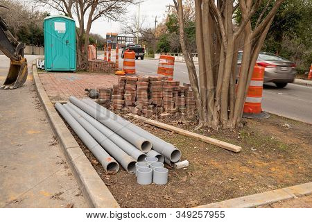 Construction Site On City Street With Materials, Porta Potty And Traffic.
