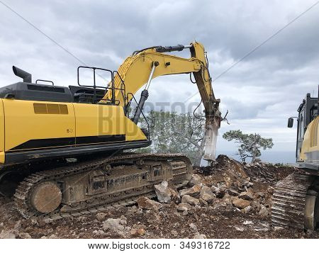 Excavator And Hydrohammer During Road Construction On The Rocky Soils