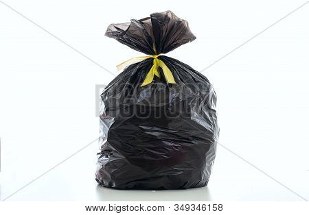 Trash, Black Garbage Bag Full And Tied Isolated Against White Background