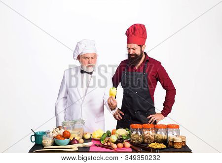 Healthy Food. Professional Culinary. Chef. Two Chefs With Vegetable. Bearded Man In Kitchen Apron. B