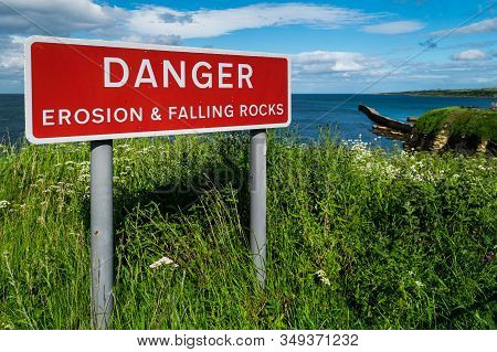 Red Sign Warning Of Eroded Coatal Cliffs Near Saint Andrews, Scotland.