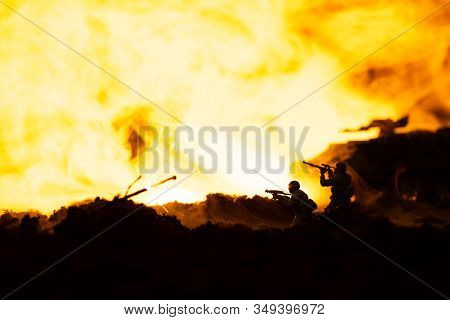 Battle Scene With Toy Soldiers And Tank On Battleground With Fire At Background