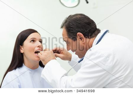 Doktor při pohledu na svého pacienta ve vyšetřovací místnosti ústí