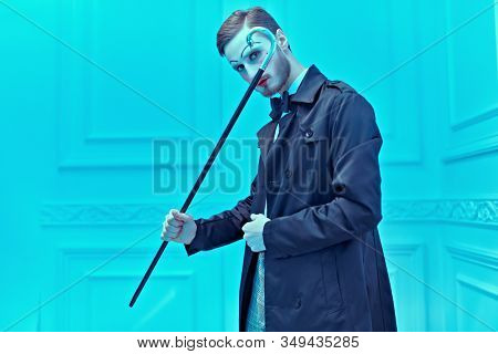 Art and fashion. A young man with makeup in the style of the 20s poses in an elegant suit in a classic vintage interior. Male mime artist.