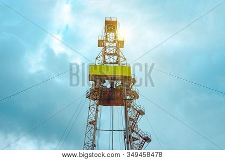 Oil And Gas Drilling Rig Onshore Dessert With Dramatic Cloudscape. Oil Drilling Rig Operation On The