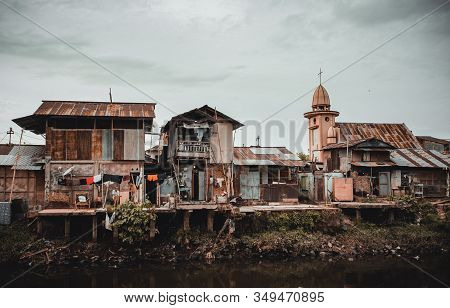 Manado, North Sulawesi, Indonesia - August 3, 2015: View Of A Ghetto By A River With Pollution, The 