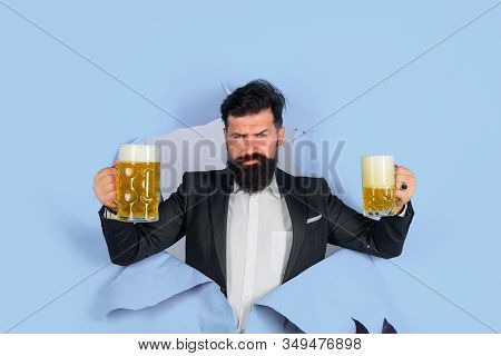 Lager And Dark Beer. Bearded Man Holds Craft Beer Looking Through Paper Hole. Drinks, Alcohol, Leisu