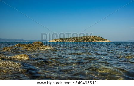 Mediterranean Sea Side Water Lagoon Scenic Landscape View Of Island And Rocky Shore Line Foreground 