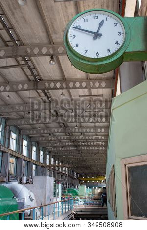 An Industrial Clock Pointing At Ten To One. Inside An Old Oil Powered Power Station