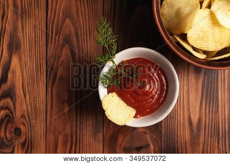 Wavy, Potato Chips In A Plate With Ketchup On A Wooden Table. Top View Of Snacks. Stock Photo Potato