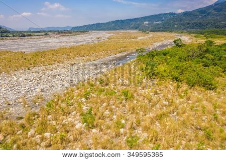 landscape of golden miscanthus with mountain and river under sky