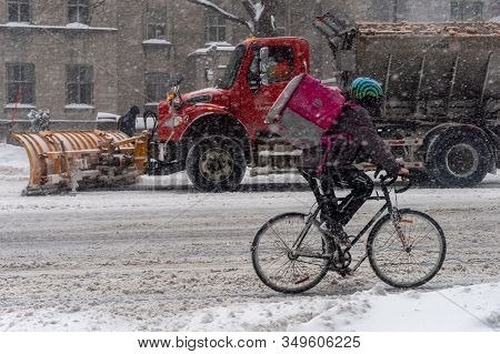 Montreal, Ca, 7 February 2020: Man Riding Bike In Downtown Montreal During Snow Storm