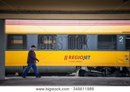 Prague, Czechia - November 2, 2019: Man Walking In Front Of A Passenger Car Of Train Belonging To Re