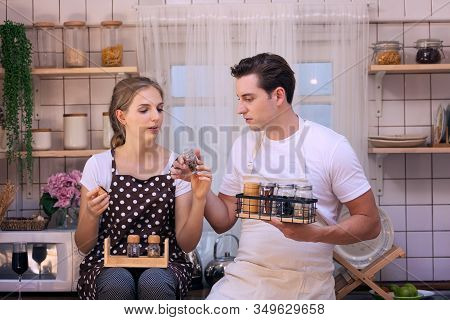 Young Couples Are Happily Choosing The Ingredients Or Raw Material Before Cooking Dinner In The Kitc