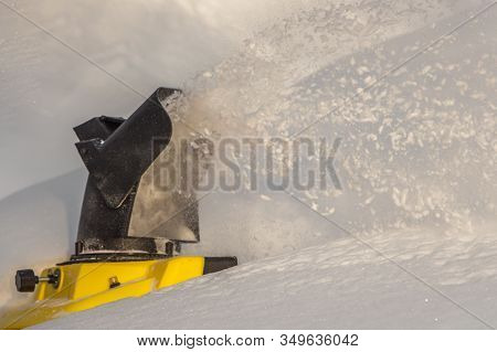 Man Is Brushing White Snow With The Yellow Electric Snow Thrower In A Winter Garden