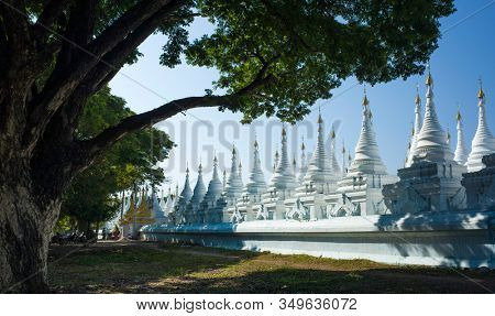 White pagodas of Sanda Muni Paya Buddhist stupa in Mandalay, Myanmar