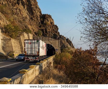 Truck Carrying Freights Entering A Tunnel On A Beautiful Mountain Road. This Is A Schmitz Cargobull 