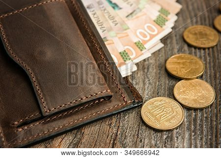 Brown Leather Wallet With Banknotes And Coins On Old Wooden Surface. Close Up.