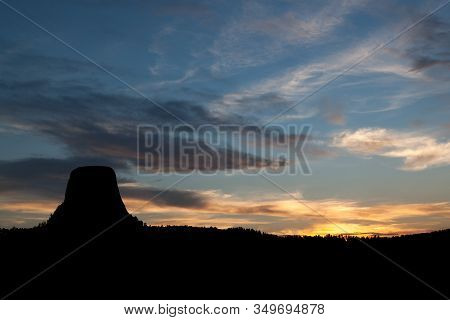 A Silhouetted Devils Tower National Monument With Fading Color In The Sky From The Setting Sun.