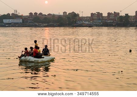 Kolkata, India - March 11, 2019: Indian Children Sail On Homemade Raft On Hooghly Or Ganga In Sunset