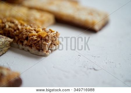 Close up on healthy granola fit bars arragement. Placed on white table. Diet composition with selective focus.
