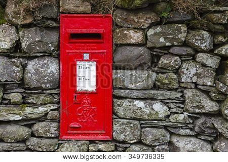 Buttermere, England - March 31:  A Traditional Red English Letterbox Mounted In A Dry Stone Wall In 