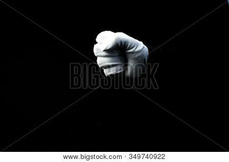A Hand Wearing White Glove On Black Background Showing A Fist
