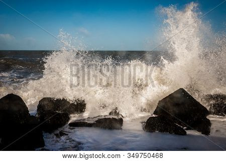 Pier At Corner Of Holland, With Basalt Blocks And Splashing And Foamy North Sea Water In The Winter 