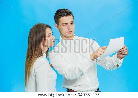 Serious Director And His Assistant Checking Documentation And Looking For Mistakes Over Blue Backgro