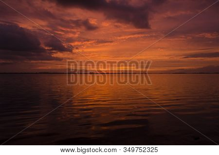 Sunset Over Lake Chascomus, Orange Cloudy Beautiful Sky Reflected In The Water Surface. Province Of 