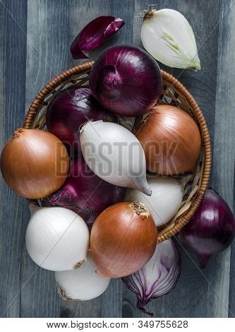 Large Bulbs Of Yellow, Red And White Onions Close-up In A Wicker Basket