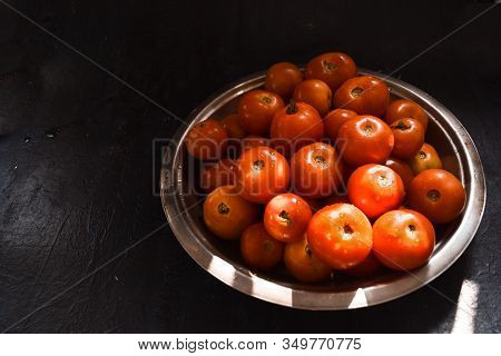 Fresh Harvested Sunkissed Ripe Red Tomatoes Kept In A Rustic Steel Plate In A Sunny Place In Kitchen
