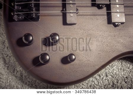 Bass Electric Guitar With Four Strings Closeup. Detail Of Popular Rock Musical Instrument. Close Vie