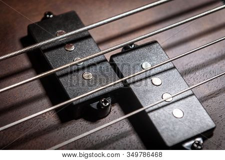 Bass Electric Guitar With Four Strings Closeup. Detail Of Popular Rock Musical Instrument. Close Vie