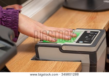 The Process Of Scanning Fingerprints During The Check At Border Crossing. Female Hand Puts Fingers T