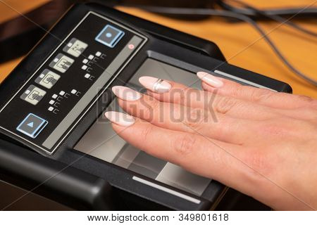 The Process Of Scanning Fingerprints During The Check At Border Crossing. Female Hand Puts Fingers T