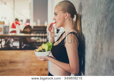 Beautiful Young Lady With Salad In The Gym. Sport Women Exercise With Healthy Food. Mental Health An