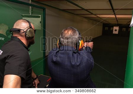 Shooting In The Dash Of Short-barreled Weapons. A Man Aims At A Target Before Firing A Pistol. The I